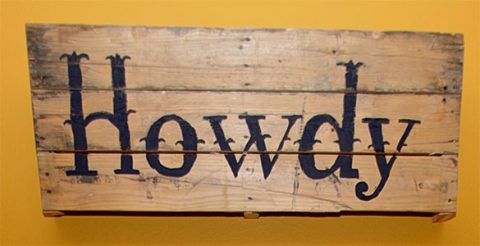Rustic 'Howdy' Wooden Sign Wooden sign with the word 'Howdy' painted in bold black rustic lettering.