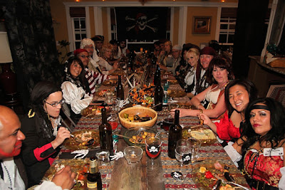 Night of Mystery | Party of the Month: Martha Stewart has nothing on her! a group of people sitting at a table with food and drinks